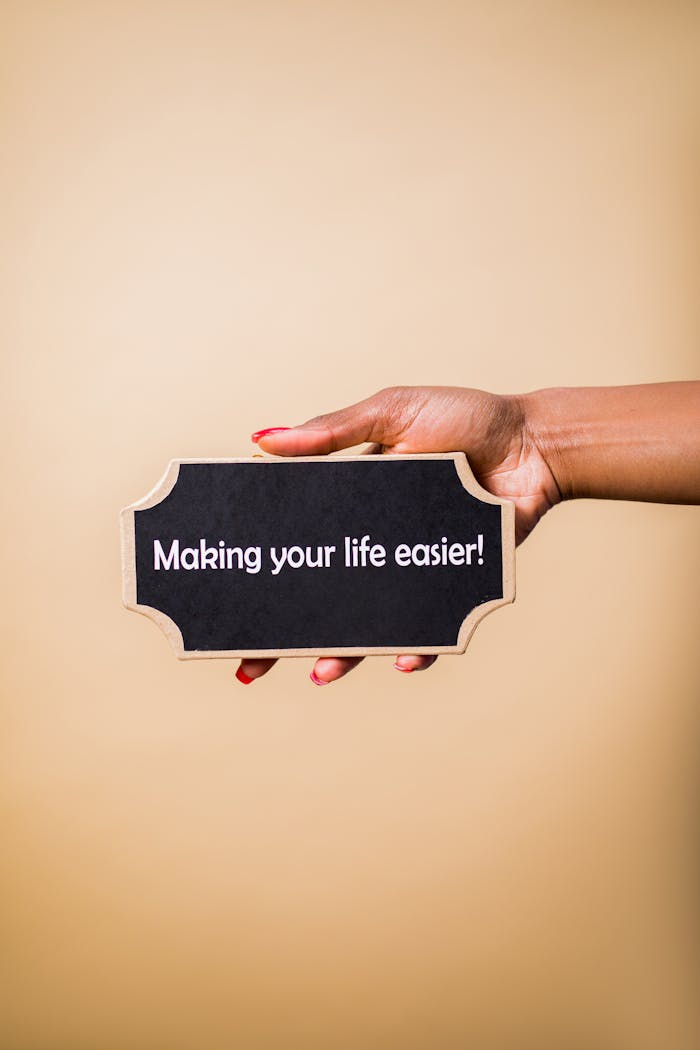 Close-up of a hand holding a sign that reads 'Making your life easier.' Perfect for motivational content.